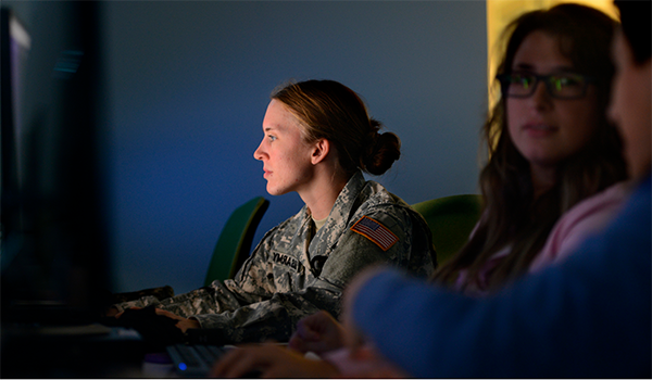 two students discussing while a third views a computer screen